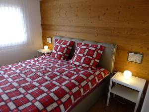 sypialnia z łóżkiem i dwoma stołami z lampkami w obiekcie Elfe-Apartments Studio for 2 adults, balcony with lake and mountain view w mieście Emmetten