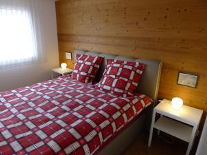 una camera con un letto e due tavoli con lampade di Elfe Apartments Studio for 2 adults, balcony with lake and mountain view a Emmetten
