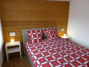 una camera con un letto con una coperta a scacchi rossa e bianca di Elfe Apartments Studio for 2 adults, balcony with lake and mountain view a Emmetten