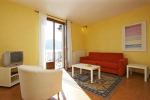 ein Wohnzimmer mit einem roten Sofa und einem TV in der Unterkunft La Terrazza in Carmine