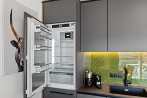 a kitchen with an open refrigerator with a dog in it at Seequartier 2 - neu & hochwertig in Friedrichshafen