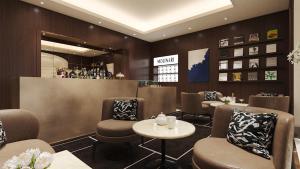 una sala d'attesa con sedie e un bar di The First Arte - Preferred Hotels & Resorts a Roma
