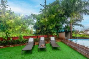 un patio con sillas, una mesa y una piscina en EKOSTAY Gold - Iris Villa en Lonavala