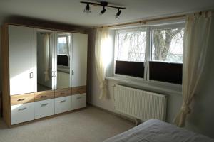 1 dormitorio con armarios blancos y ventana grande en Ferienwohnung Naeve, en Barderup