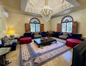ein Wohnzimmer mit blauen Möbeln und einem Kronleuchter in der Unterkunft Villa Ross in Marrakesch