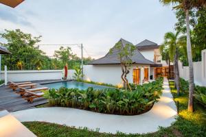 a backyard with a swimming pool and a house at Bingin Sebelas in Uluwatu