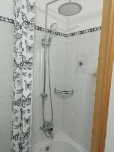 a shower with a shower curtain with butterflies on it at CHERISH in Novalja