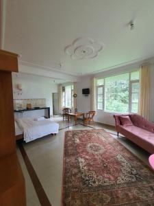 a large living room with a pink couch and a bed at The Cocoon Project in McLeod Ganj