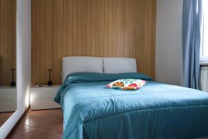 a bed with a blue comforter and a pillow on it at Saporedilago in Peschiera del Garda