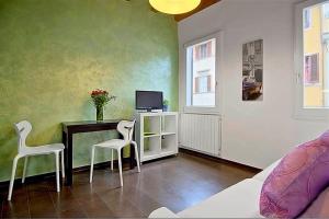 Cette chambre comprend un bureau avec deux chaises et une télévision. dans l'établissement Apartments Florence - San Gallo 3, à Florence