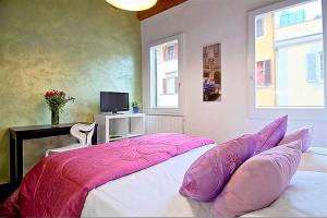 a bedroom with a bed with pink sheets and a tv at Apartments Florence - San Gallo 3 in Florence