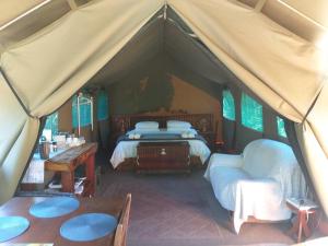 ウィルダネスにあるWilderness Glamping Tentsのテント付きの部屋(ベッド2台、テーブル付)