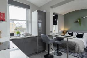 a bedroom with a bed and a desk and a sink at Stunning studio flat in the heart of Brighton in Brighton & Hove