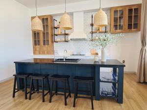 a kitchen with a blue island with bar stools at TerraCotta Beachfront Villa Phan Thiet in Phan Thiet
