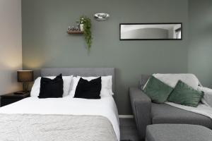 a bedroom with a bed and a chair and a mirror at Stunning studio flat in the heart of Brighton in Brighton & Hove