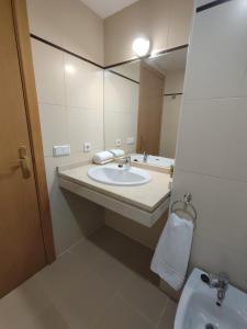 a bathroom with a sink and a mirror at Apartamento en Sevilla con piscina y parking in La Algaba