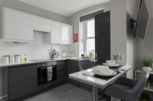 a kitchen with a table with chairs and a tableasteryasteryasteryasteryasteryastery at Stunning studio flat in the heart of Brighton in Brighton & Hove