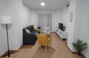 sala de estar con sofá y TV en Apartamento en Sevilla con piscina y parking, en La Algaba