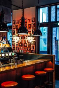 un bar con sgabelli rossi in un ristorante di St Christophers Inn at The Winston ad Amsterdam