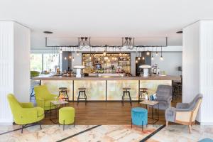 美洲海灘的住宿－Alexandre Hotel La Siesta，酒吧配有五颜六色的椅子和柜台