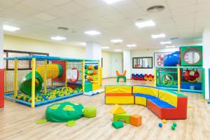 una sala de juegos para niños con juguetes y equipo de juegos en Alexandre Hotel La Siesta en Playa de las Américas