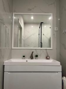 a white bathroom with a sink and a mirror at ЖК Lake town 3 in Almaty