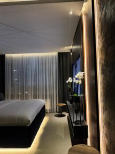 Habitación de hotel con cama y ventana grande en Olivia Rooms en Belgrado