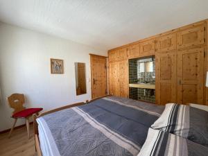 1 dormitorio con 1 cama y 1 silla roja en Chesa La Furia, en Pontresina