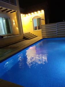 Riḩāb的住宿－شاليه الضياء，夜晚在房子前面的蓝色游泳池