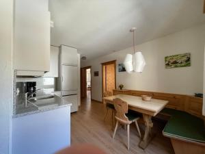 eine Küche mit einem Holztisch und einem Esszimmer in der Unterkunft Chesa La Furia in Pontresina