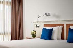 Cette chambre d'hôtel dispose d'un lit avec des oreillers bleus. dans l'établissement NH Sintra Centro, à Sintra