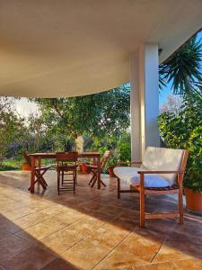 eine Terrasse mit einem Tisch und Stühlen auf einer Veranda in der Unterkunft Da Nella Dimora di Campagna in Vasto