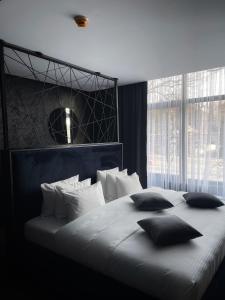 ein Schlafzimmer mit einem großen weißen Bett und Kissen in der Unterkunft Olivia Rooms in Belgrad