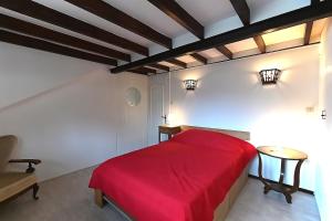 a bedroom with a red bed and a table at Villa P'tite Noisette - charmante maison vue montagne in La Bresse
