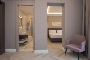 a room with a bathroom with a bed and a chair at Hotel Viminale in Rome