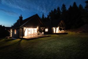 a cabin at night with lights in the yard at Bukolik in Bukowiec
