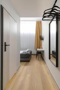 Schlafzimmer mit einem Bett, einem Spiegel und einem Tisch in der Unterkunft Zefiro Na Gnilnej in Danzig