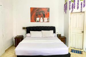 1 dormitorio con 1 cama grande con sábanas blancas en RedDoorz Syariah Near Balai Meuseuraya Aceh en Lamnyong