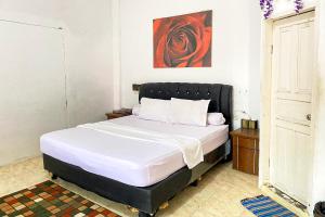 1 dormitorio con 1 cama con cabecero negro en RedDoorz Syariah Near Balai Meuseuraya Aceh en Lamnyong