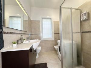 a bathroom with a sink and a shower and a toilet at Marconi Suite [free parking / near the airport] in Bologna