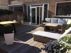 een patio met een bank en een tafel op een terras bij 'Nieuw' Strand 83 - Family house in Egmond aan Zee
