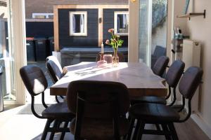 een eettafel met stoelen en een tafel met bloemen erop bij 'Nieuw' Strand 83 - Family house in Egmond aan Zee