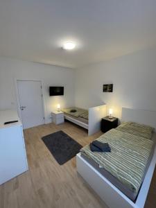 a bedroom with two beds and a refrigerator at Unterkunft Kalkwitz in Calau