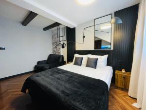 ein Hotelzimmer mit einem Bett und einem Stuhl in der Unterkunft Hotel Millennium in Przasnysz