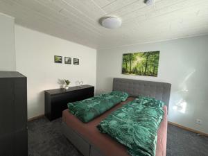 a bedroom with a bed with a green comforter at Haus am Finowkanal in Eberswalde