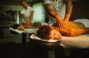 un homme qui reçoit un massage d'un autre homme dans un lit dans l'établissement Romantik Spa Hotel Elixhauser Wirt, à Elixhausen