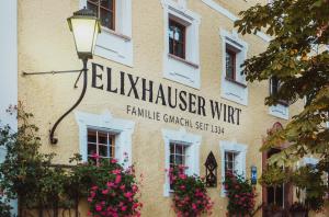 a sign on the side of a building with flowers at Romantik Spa Hotel Elixhauser Wirt in Elixhausen