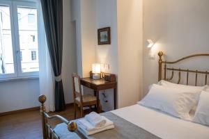 a bedroom with a bed and a table with a chair at Residenza degli Speziali in Florence