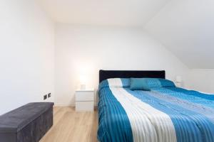 una camera da letto con un letto con un piumone blu e bianco di Motor Valley PentHouse - B&B Al Caminetto a Modena Altre 8 foto