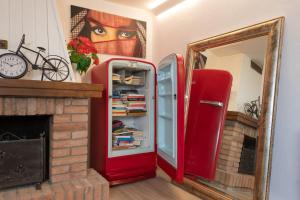 frigorifero rosso in camera con specchio di Motor Valley PentHouse - B&B Al Caminetto a Modena
